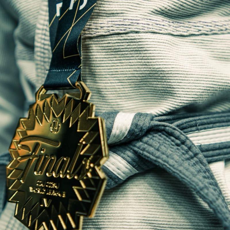Close-up of a JJWL Finals gold medal on a gi